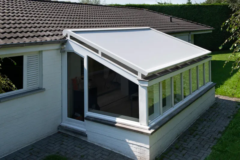 Weisses Textildach B128 über einer verglasten Veranda an einem Haus mit Ziegeldach