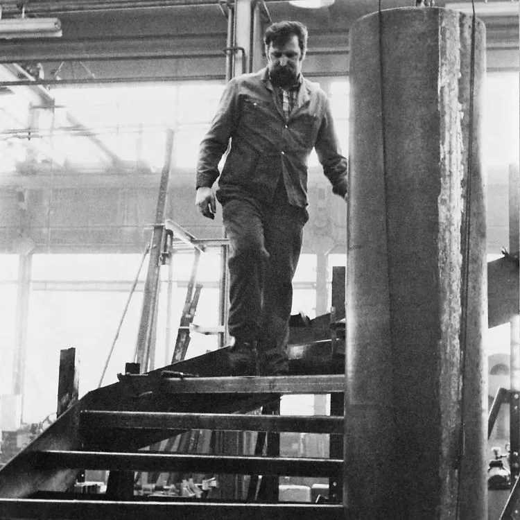 Mitarbeiter der Thalhammer-Werkstatt auf einer Stahltreppe in der Metallbauhalle in Birmenstorf