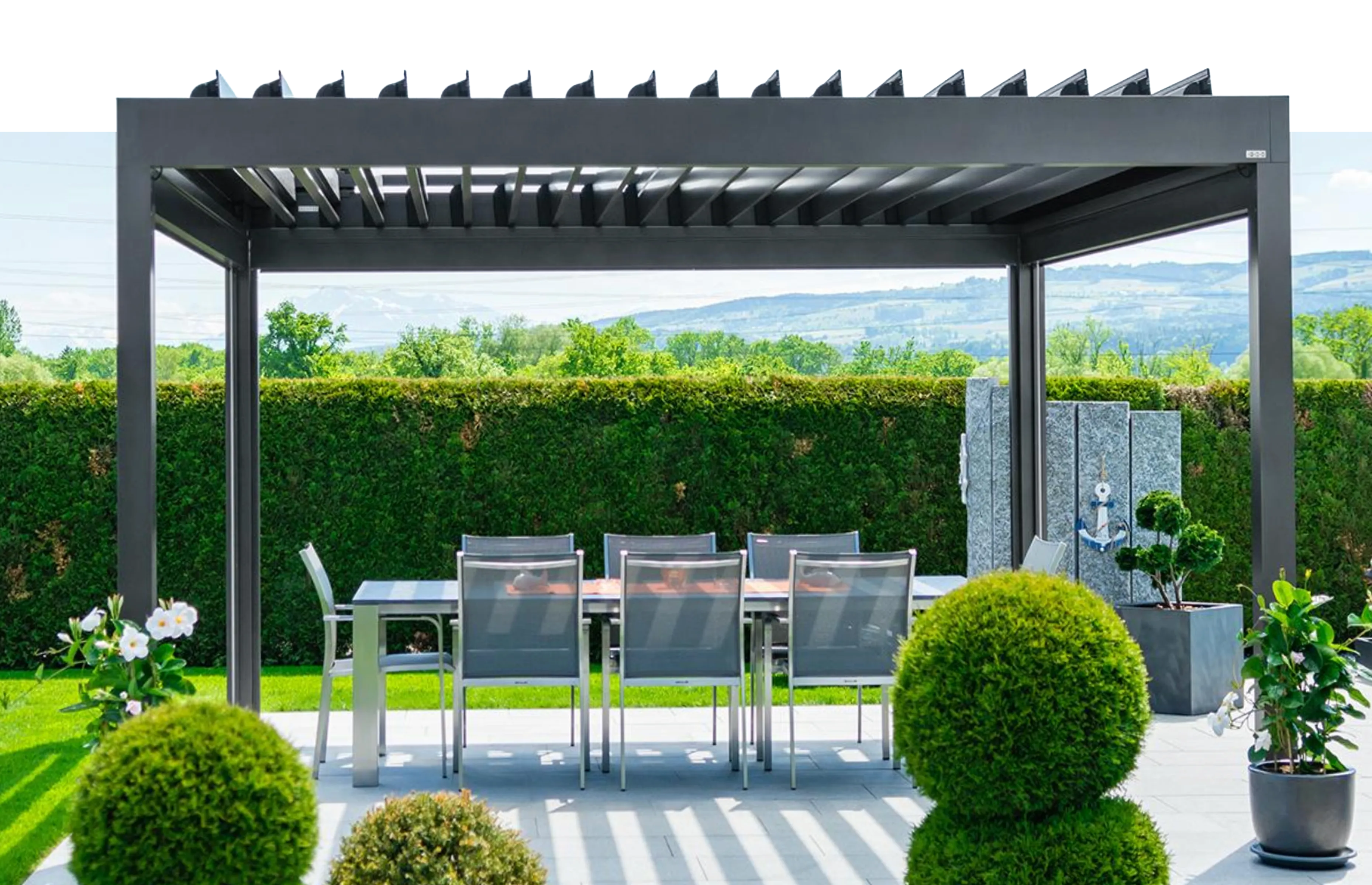 Pergola mit Lamellendach über einer Terrasse im Grünen