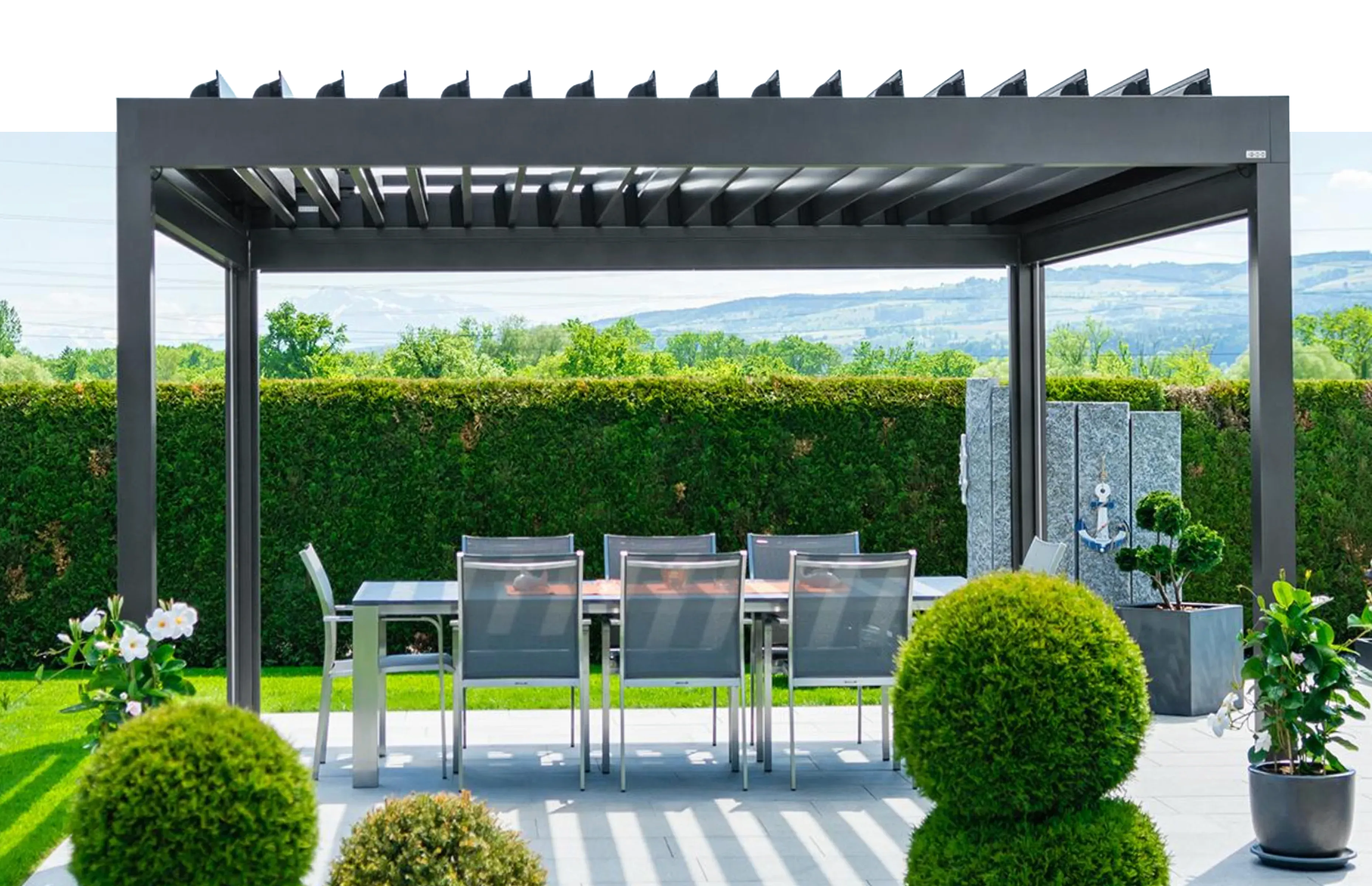 Pergola mit Lamellendach über einer Terrasse im Grünen