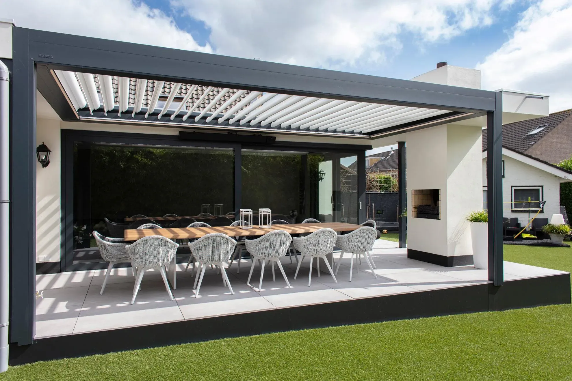 Anthrazitfarbene Pergola mit verstellbarem Lamellendach über einer Essterrasse